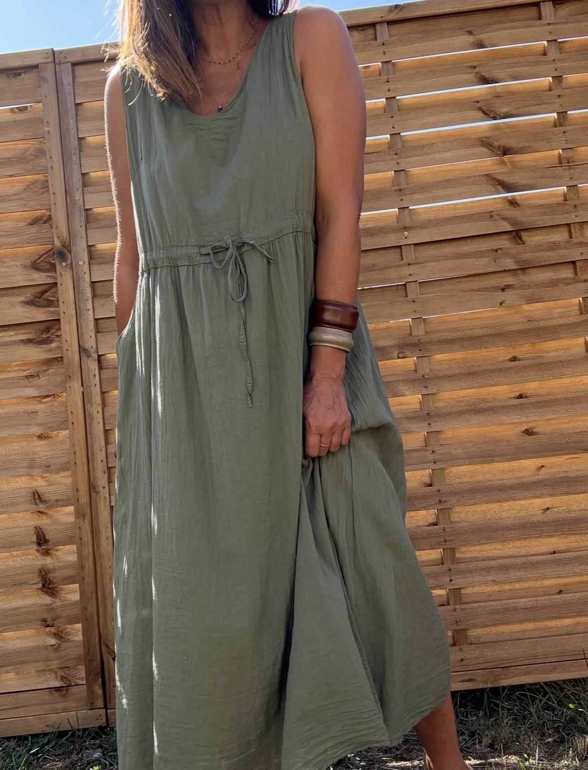 Robe ELYNE – voile de coton doublé, coloris kaki Description La robe ELYNE est une robe bohème chic, fidèle à l’univers Les Marques de Lilo. Fabriquée en Italie, elle est conçue en voile de coton doublé, fluide et agréable. Sa coupe ample et sans manche offre une grande liberté de mouvement. Son lien à nouer permet de marquer la taille ou non, selon l’envie du jour. Détails du produit Matière : voile de coton doublé Sans manche Coupe ample Lien à nouer à la taille Poches sur les côtés Coloris : kaki (aussi disponible en camel et marine) Taille unique (convient du 36 au 40) Fabrication italienne Look : bohème chic Conseils de style Portez ELYNE avec des sandales en fin d’été ou avec un pull oversize à l’automne. Ajoutez un gilet et des bottines pour un look cocooning bohème. Pourquoi on l’aime ? Simplicité : une coupe facile à vivre Féminité : une silhouette élégante et douce Efficacité : une robe tout terrain, au style affirmé Entretien Lavage à froid ou programme délicat Séchage à plat recommandé Repassage doux si nécessaire