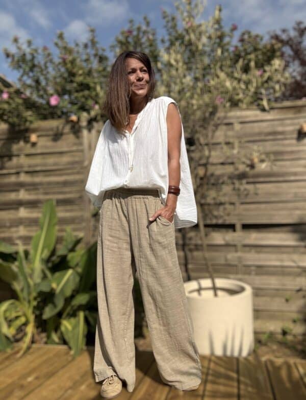 Pantalon Honoré – coton camel – coupe large Craquez pour le pantalon Honoré, un modèle large et fluide, confectionné dans un coton camel léger et agréable à porter. Sa coupe ample assure un style décontracté mais toujours élégant. Il convient parfaitement aux journées actives ou aux moments de détente. La taille élastique s’adapte naturellement à votre silhouette. Elle offre un confort optimal, du matin jusqu’au soir. Ce modèle en taille unique convient aux morphologies allant du 36 au 42. Il s’enfile facilement et épouse les formes sans les contraindre. Les poches latérales ajoutent une touche pratique à ce basique du dressing estival. Vous pouvez y glisser vos essentiels en toute simplicité. Grâce à sa matière légère en coton, ce pantalon reste respirant et agréable à porter même sous les fortes chaleurs. Coupe : Large et fluide Taille : Élastique – convient du 36 au 42 Matière : 100 % coton léger Coloris : Camel Détails : Poches latérales Style : Décontracté, bohème, chic Facile à associer avec une chemise fluide, un t-shirt blanc ou une blouse en lin. Un pantalon pensé pour vous offrir liberté, confort et style en un seul geste. Quantités limitées – ne manquez pas ce basique chic de saison.