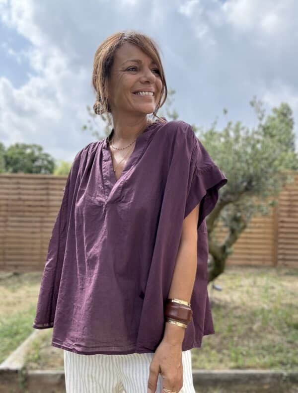 Blouse THEA – Prune Description Blouse ample sans manches en voile de coton, dans un coloris prune profond et raffiné. Un indispensable bohème chic à porter dès la fin de l’été et jusqu’au début de l’automne. Confortable, féminine et facile à associer. Matière : Voile de coton Coupe : Ample et fluide Style : Sans manches, col rond Couleur : Prune Taille : Unique (convient du 36 au 44) Fabriquée en : Italie Conseil style : elle se marie très bien avec un pantalon écru, un jean brut ou le pull NOÉ en maille beige pour un look doux et sophistiqué. Livraison & retours Livraison rapide sous 2 à 4 jours ouvrés – Retour accepté sous 14 jours. Ajouter au panier