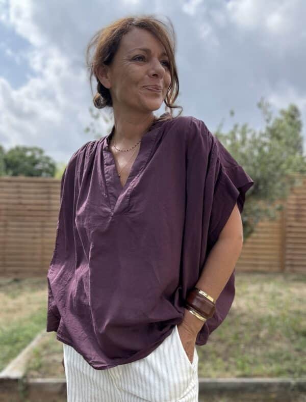 Blouse THEA – Prune Description Blouse ample sans manches en voile de coton, dans un coloris prune profond et raffiné. Un indispensable bohème chic à porter dès la fin de l’été et jusqu’au début de l’automne. Confortable, féminine et facile à associer. Matière : Voile de coton Coupe : Ample et fluide Style : Sans manches, col rond Couleur : Prune Taille : Unique (convient du 36 au 44) Fabriquée en : Italie Conseil style : elle se marie très bien avec un pantalon écru, un jean brut ou le pull NOÉ en maille beige pour un look doux et sophistiqué. Livraison & retours Livraison rapide sous 2 à 4 jours ouvrés – Retour accepté sous 14 jours. Ajouter au panier