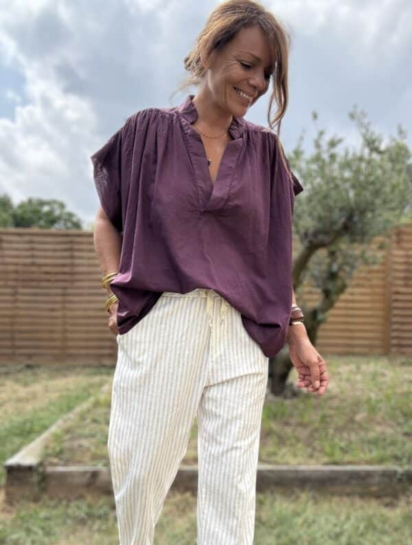 Blouse THEA – Prune Description Blouse ample sans manches en voile de coton, dans un coloris prune profond et raffiné. Un indispensable bohème chic à porter dès la fin de l’été et jusqu’au début de l’automne. Confortable, féminine et facile à associer. Matière : Voile de coton Coupe : Ample et fluide Style : Sans manches, col rond Couleur : Prune Taille : Unique (convient du 36 au 44) Fabriquée en : Italie Conseil style : elle se marie très bien avec un pantalon écru, un jean brut ou le pull NOÉ en maille beige pour un look doux et sophistiqué. Livraison & retours Livraison rapide sous 2 à 4 jours ouvrés – Retour accepté sous 14 jours. Ajouter au panier