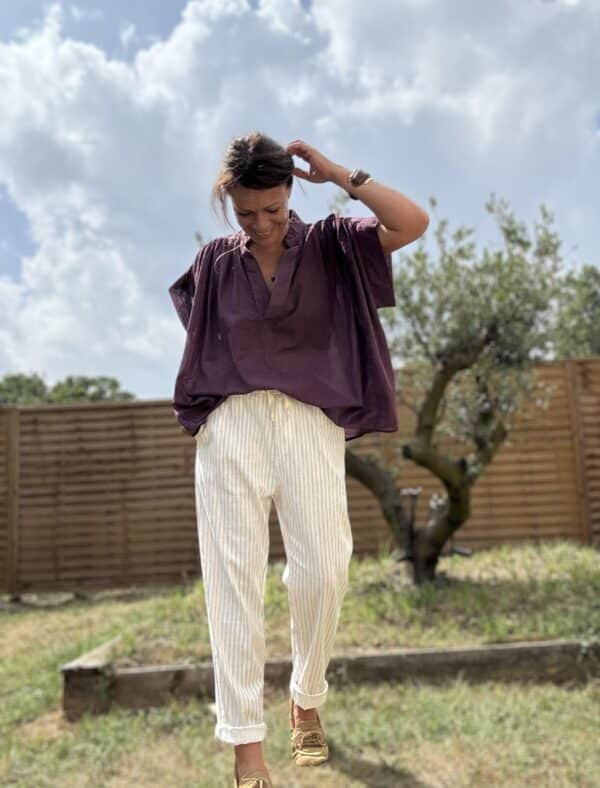 Blouse THEA – Prune Description Blouse ample sans manches en voile de coton, dans un coloris prune profond et raffiné. Un indispensable bohème chic à porter dès la fin de l’été et jusqu’au début de l’automne. Confortable, féminine et facile à associer. Matière : Voile de coton Coupe : Ample et fluide Style : Sans manches, col rond Couleur : Prune Taille : Unique (convient du 36 au 44) Fabriquée en : Italie Conseil style : elle se marie très bien avec un pantalon écru, un jean brut ou le pull NOÉ en maille beige pour un look doux et sophistiqué. Livraison & retours Livraison rapide sous 2 à 4 jours ouvrés – Retour accepté sous 14 jours. Ajouter au panier
