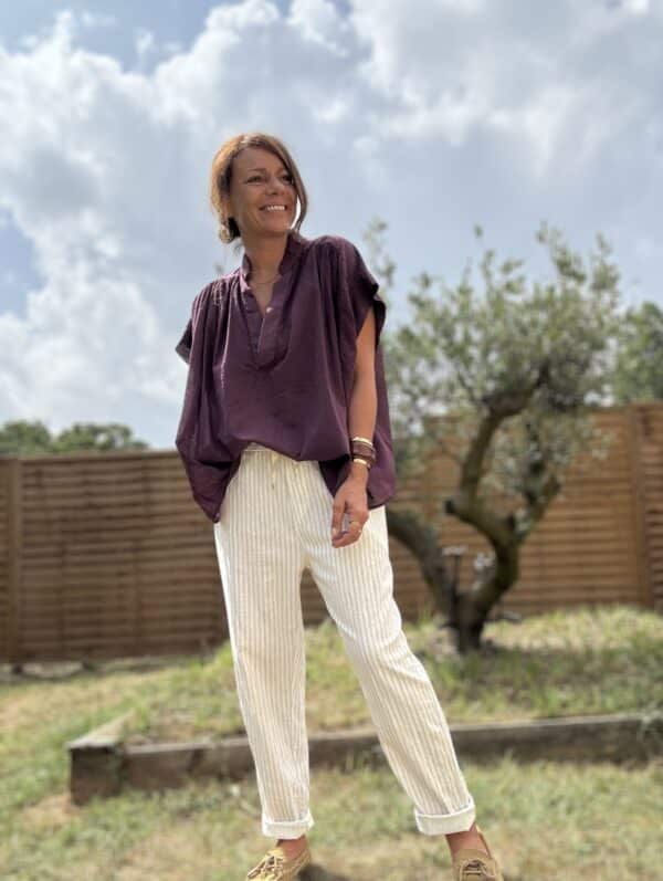 Blouse THEA – Prune Description Blouse ample sans manches en voile de coton, dans un coloris prune profond et raffiné. Un indispensable bohème chic à porter dès la fin de l’été et jusqu’au début de l’automne. Confortable, féminine et facile à associer. Matière : Voile de coton Coupe : Ample et fluide Style : Sans manches, col rond Couleur : Prune Taille : Unique (convient du 36 au 44) Fabriquée en : Italie Conseil style : elle se marie très bien avec un pantalon écru, un jean brut ou le pull NOÉ en maille beige pour un look doux et sophistiqué. Livraison & retours Livraison rapide sous 2 à 4 jours ouvrés – Retour accepté sous 14 jours. Ajouter au panier