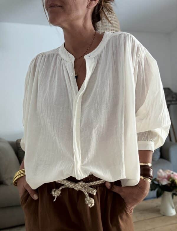 Chemise ample écrue en voile de coton – GIGI La chemise GIGI écrue en voile de coton offre confort, fluidité et élégance pour toutes vos tenues de saison. Sa coupe ample s’adapte du 36 au 42 et met en valeur toutes les silhouettes. Le col Mao et la boutonnière discrète ajoutent une touche contemporaine et minimaliste. Les manches longues se ferment par un bouton raffiné, à porter longues ou retroussées selon vos envies. Le voile de coton léger rend cette pièce agréable même sous des températures estivales. Fabriquée en Italie, elle bénéficie d’une coupe soignée et d’une qualité durable. Sa couleur écrue s’associe facilement avec vos jeans, pantalons en lin ou jupes imprimées. 🧵 Composition : 100 % voile de coton 📏 Taille unique (convient du 36 au 42) 🌿 Coloris : écru 🇮🇹 Fabrication italienne 👕 Coupe : ample 👚 Col : Mao 👖 Manches : longues avec bouton ✨ Détail : boutonnière discrète