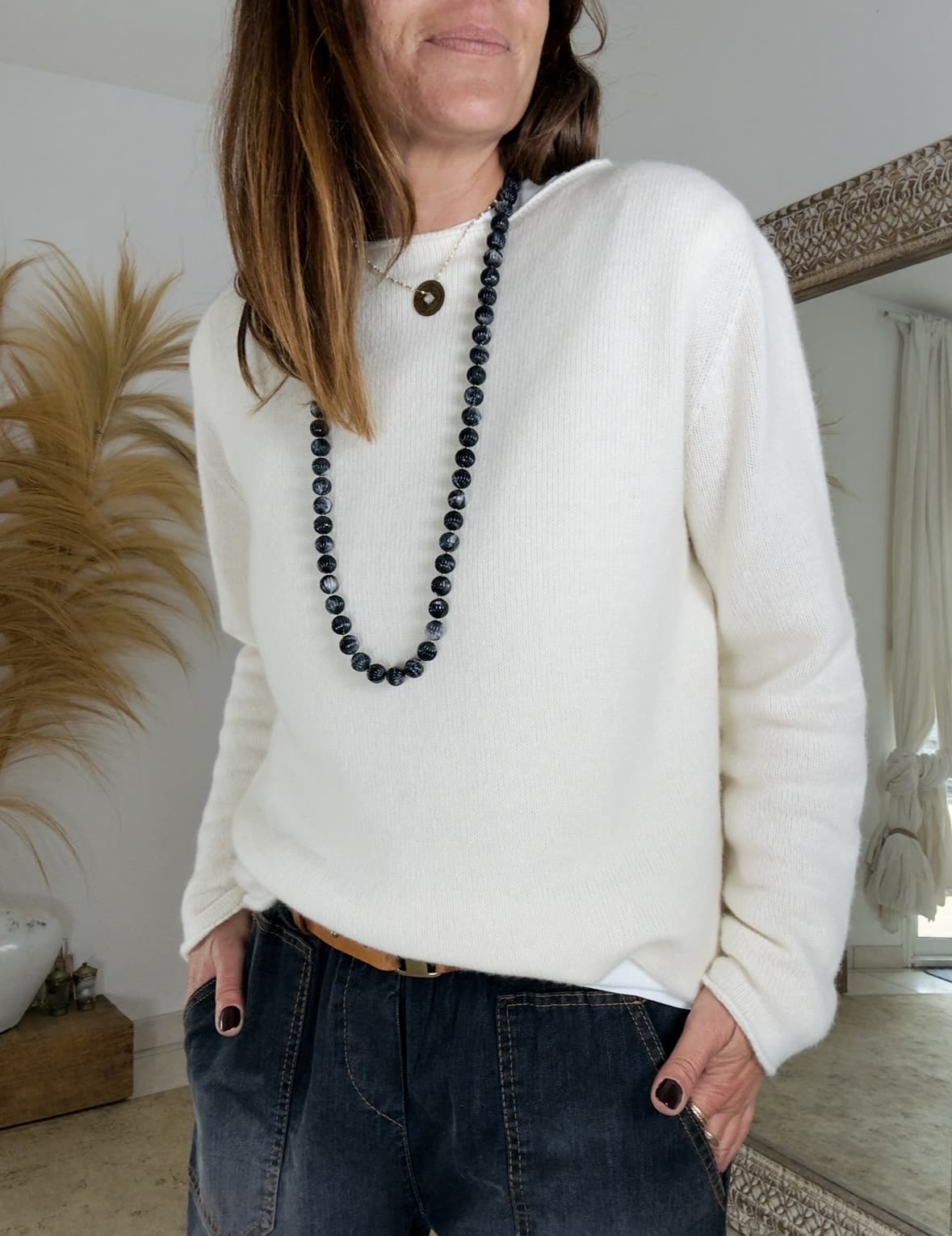 Élégance et douceur naturelle Le pull écru laine cachemire Intuition allie chaleur, légèreté et féminité. Fabriqué en Italie, il se distingue par la qualité de sa maille fine et douce. Sa coupe droite s’adapte parfaitement à la silhouette, sans être trop ample. Le col bateau met délicatement le port de tête en valeur, tout en gardant une allure simple et élégante. Les manches longues et les bords légèrement roulottés ajoutent une finition raffinée. Ce modèle intemporel se porte aisément du matin au soir, avec confort et style. Une matière noble et agréable Grâce à sa composition, ce pull écru laine cachemire offre un toucher moelleux et une chaleur douce. Il contient 45 % de laine et 10 % de cachemire, un mélange idéal pour affronter la saison froide. La maille reste respirante et légère, garantissant un confort optimal toute la journée. Ce pull ne gratte pas et accompagne les mouvements avec aisance. Il convient à une taille unique (du 36 au 42). Vous pouvez le porter seul ou sur une chemise, selon vos envies. L’accord parfait pour l’automne Pour un look chic et harmonieux, associez le pull écru Intuition au pantalon Intuition coloris chocolat foncé. Les tons neutres se marient parfaitement et créent une silhouette douce, élégante et automnale. Ce pull deviendra sans doute une pièce essentielle de votre dressing. À la fois chaud, raffiné et facile à porter, il incarne la simplicité italienne et la douceur de la saison.