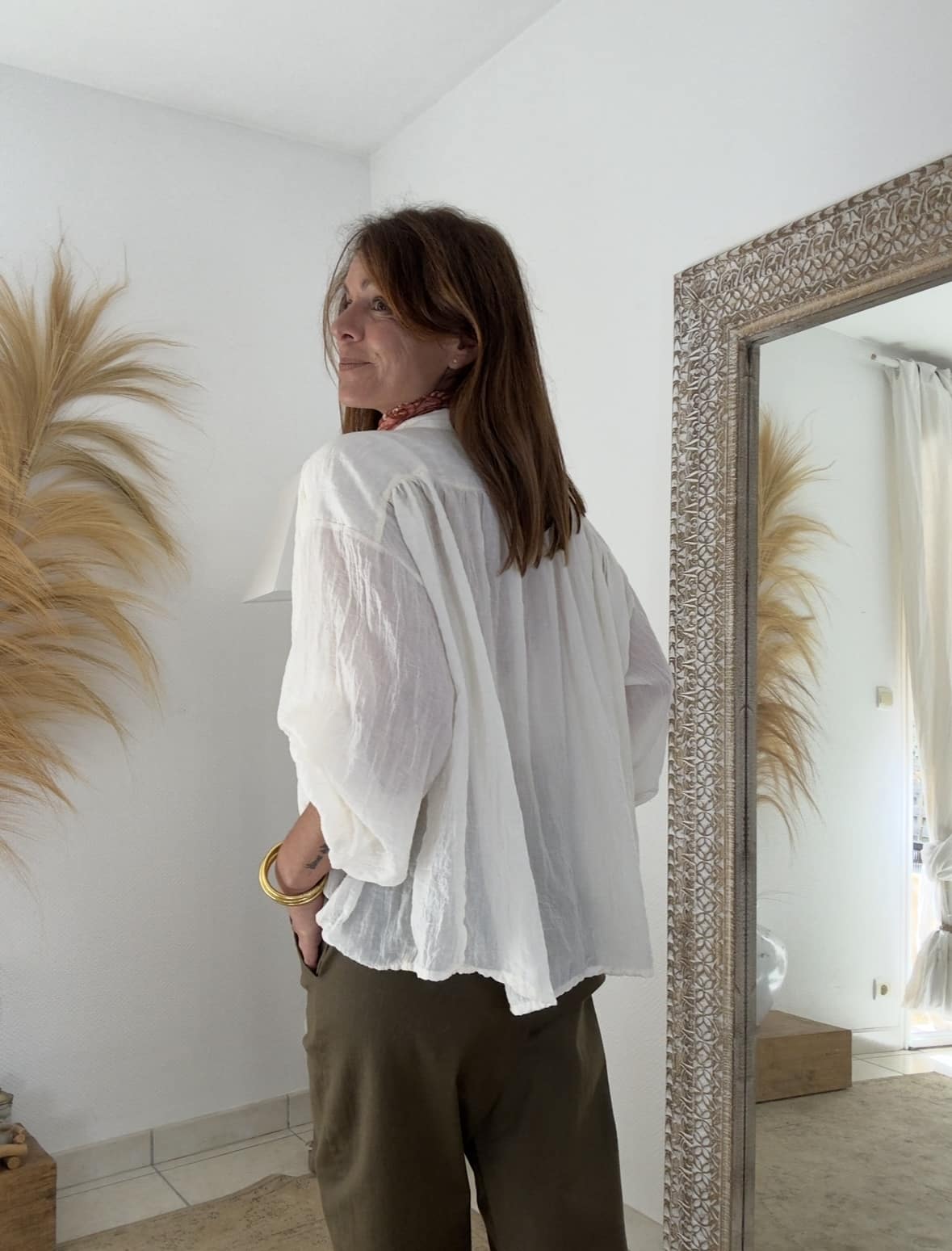 Blouse oversize écrue femme – Intuition La blouse Intuition écrue est un essentiel chic et fluide, parfait pour la mi-saison. Sa coupe oversize offre liberté et confort, tandis que son col V et ses manches boutonnées apportent une touche féminine raffinée. Une matière légère et texturée Principalement composée de coton avec une touche de polyester, la blouse écrue est légère, agréable et fluide. Son aspect légèrement gaufré lui donne un charme unique et naturel. Fabrication italienne et style polyvalent Fabriquée en Italie, cette blouse reflète le savoir-faire et l’élégance à l’italienne. Sa taille unique (38 à 44) s’adapte à toutes les silhouettes. Associez-la au pantalon Intuition camel, chocolat ou agave pour un look harmonieux et plein de douceur. Plus de douceur, plus de style, plus d’Intuition 🤍