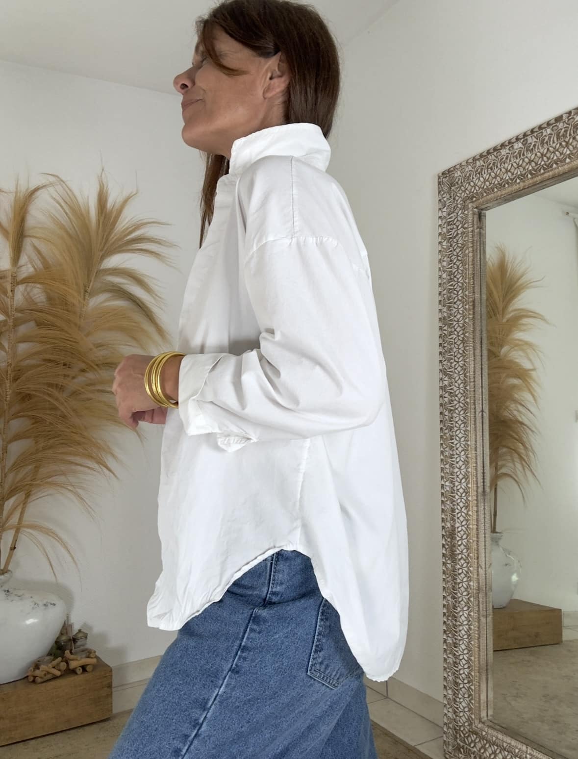 Élégance naturelle et confort absolu La chemise blanche coton oversize Intuition combine douceur, style et liberté de mouvement. Fabriquée en coton respirant, elle promet un confort idéal au quotidien. Sa coupe ample souligne une allure féminine et décontractée. Les manches longues se ferment par un bouton délicat, ajoutant une touche raffinée. Grâce à sa forme fluide, cette chemise s’adapte facilement à votre morphologie. Elle convient parfaitement aux tailles 38 à 42. Une coupe oversize pleine d’aisance Avec sa petite ouverture discrète sur les côtés, la chemise blanche coton oversize laisse le corps respirer. Elle accompagne chaque mouvement avec légèreté. Son col chemise classique structure le look, sans perdre cette touche de douceur que l’on aime tant. Portée ouverte sur un débardeur, ou boutonnée pour un effet plus habillé, elle s’adapte à chaque style. Vous pouvez la porter seule ou la glisser dans un pantalon pour marquer la taille. Des associations harmonieuses La chemise blanche Intuition s’accorde parfaitement avec le pantalon Intuition, disponible en vert agave, camel ou chocolat foncé. Ensemble, ils forment un duo élégant et moderne. Les teintes naturelles se complètent avec équilibre pour un look bohème chic. Grâce à son design intemporel, cette chemise devient un indispensable de votre dressing. Elle se porte aussi bien en semaine qu’en week-end, toujours avec grâce et simplicité.