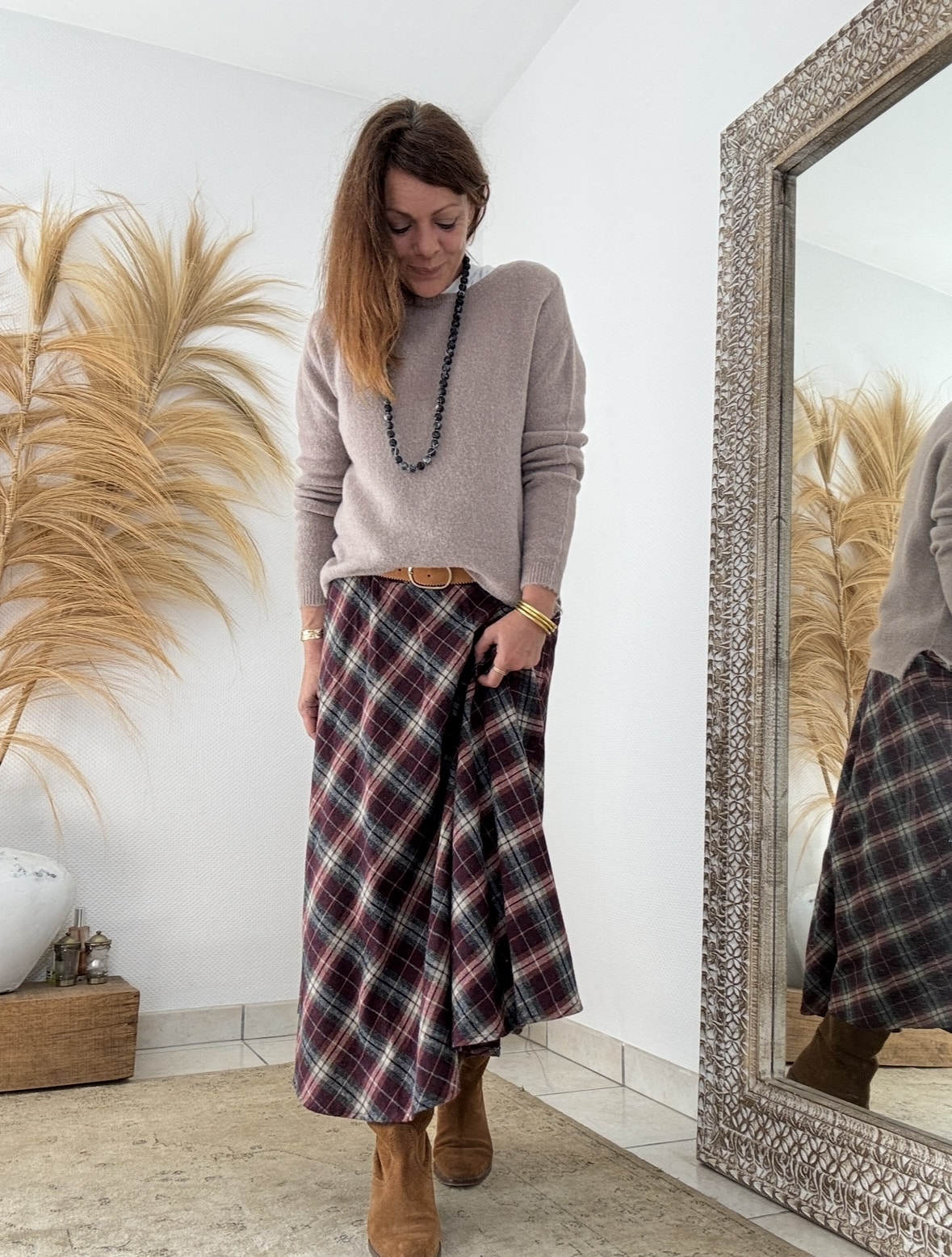 Élégance écossaise et charme bohème chic La jupe ANNA Johanna Paris séduit par son allure raffinée et naturelle. Confectionnée dans un tissu écossais Bordeaux, elle capture l’esprit bohème chic dans toute sa splendeur. Ses tons chauds et lumineux apportent caractère et douceur à chaque silhouette. Grâce à sa matière fluide, cette jupe suit le mouvement du corps avec légèreté et élégance. Son toucher laineux procure immédiatement une sensation de confort et de douceur. Aussi agréable qu’une laine légère, le tissu reste respirant et souple. La composition équilibrée en 80 % coton et 20 % polyester assure une tenue impeccable, même après lavage. Elle se porte facilement toute la journée, sans perdre sa forme ni son éclat. Une coupe féminine et confortable La taille élastique s’ajuste naturellement pour un maintien souple et agréable. Cette finition discrète sublime la taille sans la comprimer. La coupe longue, qui descend jusqu’à la cheville, allonge la silhouette et crée un effet élancé. Grâce à sa fluidité, la jupe ANNA épouse les formes sans les marquer, pour un tombé féminin et gracieux. De plus, sa taille unique (36 à 40) la rend facile à porter par de nombreuses morphologies. Polyvalente et élégante, elle s’adapte à tous les styles. Associée à une chemise fluide ou à un pull doux, elle compose un look bohème chic parfait pour l’automne et l’hiver. Une pièce phare de l’esprit Les Marques de Lilo La jupe ANNA s’accorde merveilleusement avec les teintes naturelles et les matières douces. Portez-la, par exemple, avec la chemise Namasté à carreaux Bordeaux ou la veste Lénaïc pour une allure harmonieuse. Elle incarne la philosophie de Les Marques de Lilo : une mode féminine, fluide et authentique, où chaque détail compte. Cette jupe longue écossaise devient rapidement une pièce essentielle du dressing bohème chic. À la fois douce, légère et pleine de caractère, elle conjugue confort, élégance et simplicité naturelle.