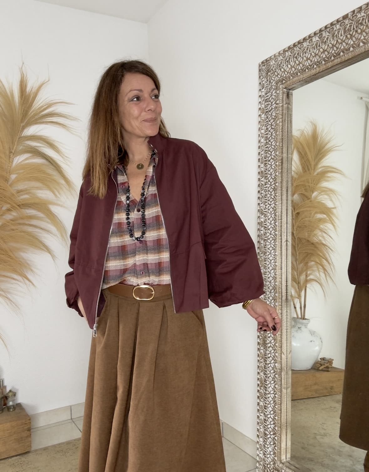 LENAÏC, la veste bordeaux au charme Intuition La veste LENAÏC de la marque Intuition séduit par son équilibre entre confort et élégance. Sa couleur bordeaux profonde attire le regard et valorise le teint. Sa matière douce et fluide épouse la silhouette avec naturel. Entièrement doublée, elle assure un confort agréable et une tenue harmonieuse. Ainsi, LENAÏC devient une pièce incontournable de mi-saison. Une coupe boule plate, féminine et actuelle Sa forme boule plate ajoute du volume sans épaissir la ligne. La silhouette reste souple, moderne et légèrement arrondie. La taille unique convient du 36 au 40 selon le rendu souhaité. De plus, le tombé fluide apporte légèreté et féminité. Cette veste s’adapte aussi bien à un style urbain qu’à une allure bohème. Des détails qui font la différence La fermeture zippée est pratique et élégante. Le bouton du col montant ajoute une touche chic et contemporaine. Les manches, plus longues que trois quarts, libèrent joliment le poignet. Les finitions discrètes témoignent d’un vrai soin de confection. Enfin, la doublure intégrale garantit une structure stable et douce. Un style fluide et des associations parfaites Le coloris bordeaux s’accorde naturellement avec les tons camel, écru ou beige. Cette teinte chaude met en valeur les peaux claires comme dorées. Portez LENAÏC sur un jean pour un look citadin élégant. Elle s’accorde aussi parfaitement avec la jupe Flora et la chemise Namasté, pour un ensemble féminin et harmonieux. Une matière douce et naturelle Confectionnée en 100% coton, LENAÏC allie confort et légèreté. La matière est respirante, agréable et résistante. Elle conserve sa souplesse tout au long de la journée. Ainsi, la veste accompagne chaque mouvement avec fluidité et aisance. En résumé La veste LENAÏC bordeaux Intuition allie modernité, douceur et confort. Sa coupe boule plate et son col montant créent une silhouette élégante. Entièrement doublée, elle s’associe à merveille avec la chemise Namasté et la jupe Flora. Un modèle intemporel et féminin, à adopter sans hésiter.