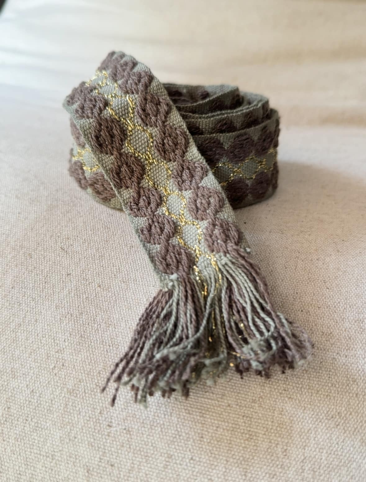 L’accessoire bohème chic par excellence La ceinture POLIG incarne l’élégance décontractée du style bohème chic. Confectionnée en coton doux, elle offre à la fois souplesse, texture et charme artisanal. Ses motifs ronds brodés couleur chocolat rappellent le travail soigné des pièces faites à la main. Le liseré doré apporte une touche de lumière et de féminité, idéale pour rehausser vos tenues. Grâce à sa matière naturelle, la ceinture POLIG reste agréable et facile à ajuster. Elle se noue simplement à la taille ou sur les hanches, selon votre style. Ses finitions à franges ajoutent un esprit libre et délicatement vintage. Chaque détail contribue à une allure féminine, naturelle et authentique. Trois coloris, trois ambiances La ceinture POLIG se décline en trois teintes élégantes et faciles à assortir : Beige : douce et lumineuse, parfaite sur une robe fluide ou une jupe claire. Kaki : naturelle et subtile, idéale pour des looks automnaux et raffinés. Camel : chaleureuse et intemporelle, un indispensable de la saison. Portée sur une robe vaporeuse, une jupe longue ou un pantalon fluide, elle structure la silhouette tout en conservant sa légèreté. Elle se noue selon vos envies : en simple tour pour un style épuré, ou en double pour un effet plus affirmé. Une signature Les Marques de Lilo La ceinture POLIG incarne parfaitement l’univers Les Marques de Lilo : un style féminin, doux et naturellement bohème. Légère, polyvalente et unique, elle complète avec grâce vos tenues du quotidien. Ses détails brodés et sa finition à franges en font un accessoire plein de caractère. Un simple nœud suffit pour souligner la taille et révéler toute votre allure bohème chic.