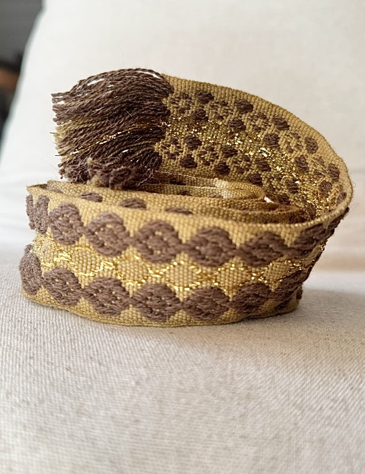 L’accessoire bohème chic par excellence La ceinture POLIG incarne l’élégance décontractée du style bohème chic. Confectionnée en coton doux, elle offre à la fois souplesse, texture et charme artisanal. Ses motifs ronds brodés couleur chocolat rappellent le travail soigné des pièces faites à la main. Le liseré doré apporte une touche de lumière et de féminité, idéale pour rehausser vos tenues. Grâce à sa matière naturelle, la ceinture POLIG reste agréable et facile à ajuster. Elle se noue simplement à la taille ou sur les hanches, selon votre style. Ses finitions à franges ajoutent un esprit libre et délicatement vintage. Chaque détail contribue à une allure féminine, naturelle et authentique. Trois coloris, trois ambiances La ceinture POLIG se décline en trois teintes élégantes et faciles à assortir : Beige : douce et lumineuse, parfaite sur une robe fluide ou une jupe claire. Kaki : naturelle et subtile, idéale pour des looks automnaux et raffinés. Camel : chaleureuse et intemporelle, un indispensable de la saison. Portée sur une robe vaporeuse, une jupe longue ou un pantalon fluide, elle structure la silhouette tout en conservant sa légèreté. Elle se noue selon vos envies : en simple tour pour un style épuré, ou en double pour un effet plus affirmé. Une signature Les Marques de Lilo La ceinture POLIG incarne parfaitement l’univers Les Marques de Lilo : un style féminin, doux et naturellement bohème. Légère, polyvalente et unique, elle complète avec grâce vos tenues du quotidien. Ses détails brodés et sa finition à franges en font un accessoire plein de caractère. Un simple nœud suffit pour souligner la taille et révéler toute votre allure bohème chic.