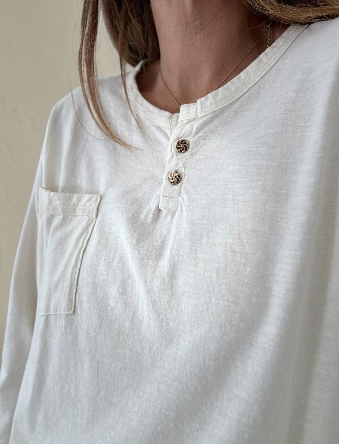Son joli col tunisien est sublimé par deux petits boutons fantaisie sur le décolleté, pour une touche délicate et féminine.
